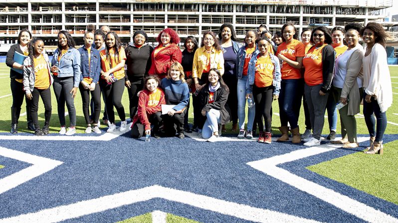 Group of students on Dallas Cowboys football field.
